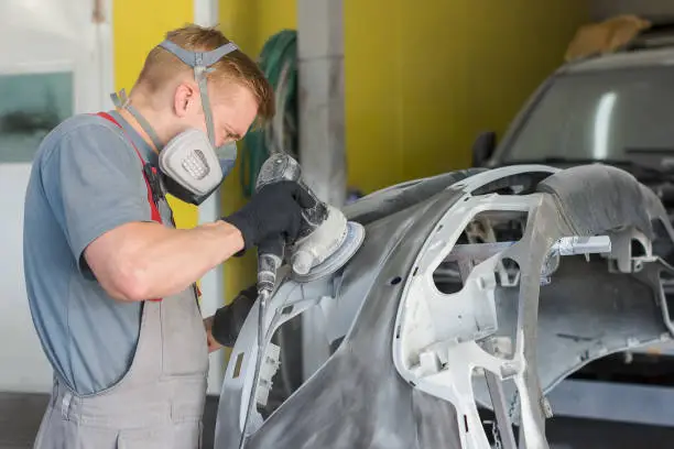 auto mechanic repairs the car body part